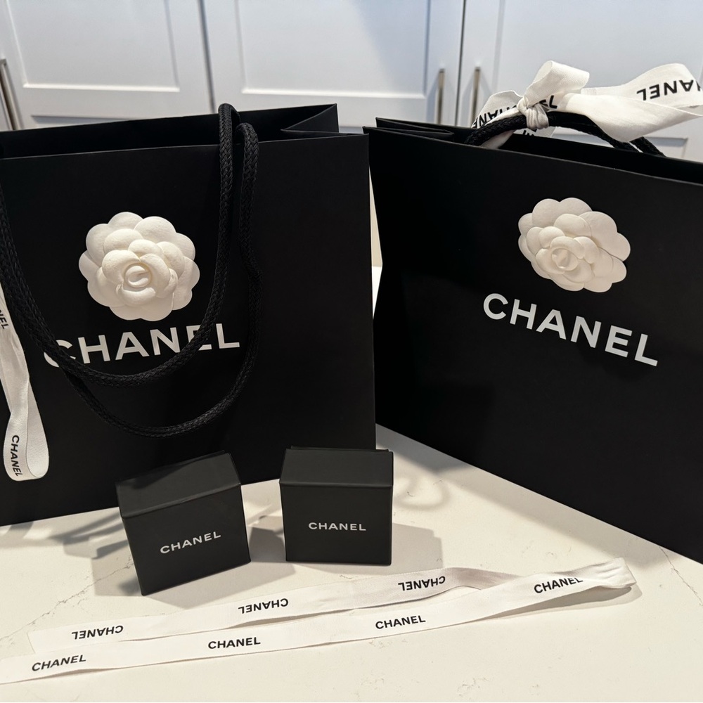 2 Chanel shopping bags with camellia flower and  ribbons, 2 small jewelry boxes.